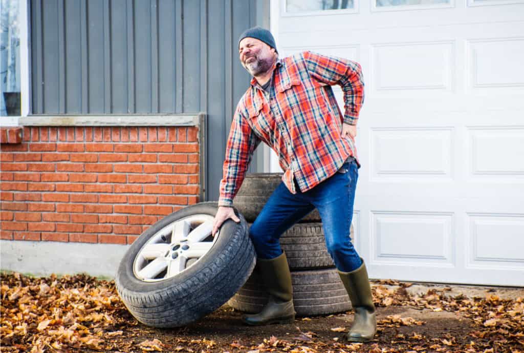 man lifting tire sudden back pain back went out chiropractor tulsa