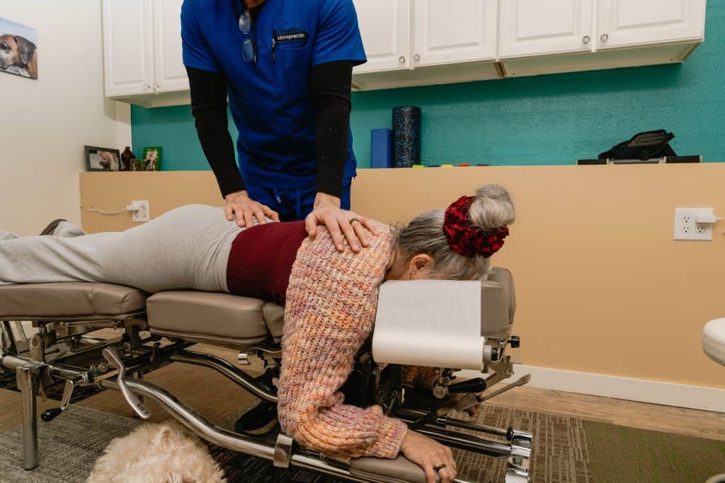 chiropractor adjusting back pain patient on table Tulsa Oklahoma