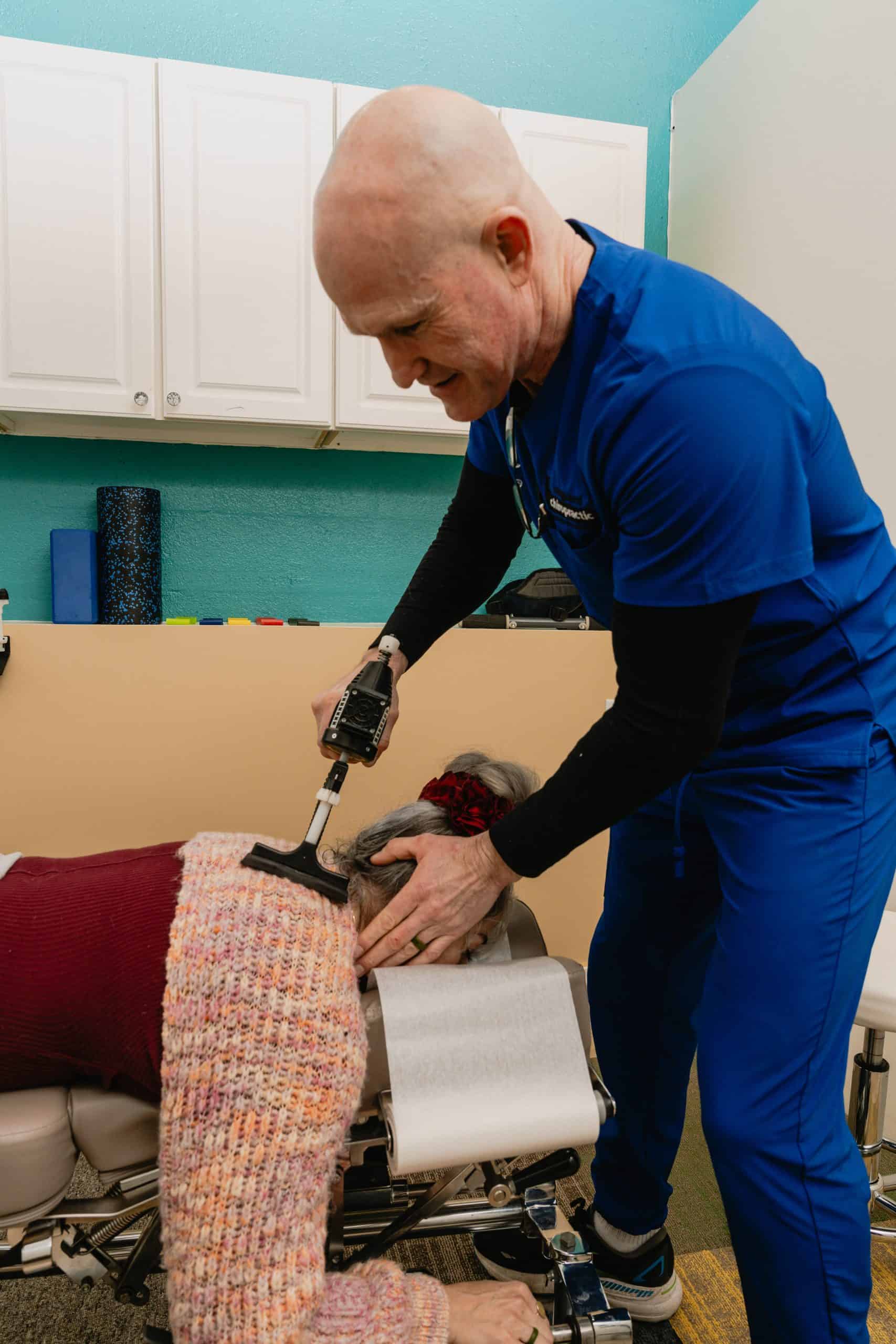 Tulsa Oklahoma chiropractors at work: Dr. Jason Forward DC delivering a chiropractic adjustment for back pain at Vanguard Chiropractic in Brookside