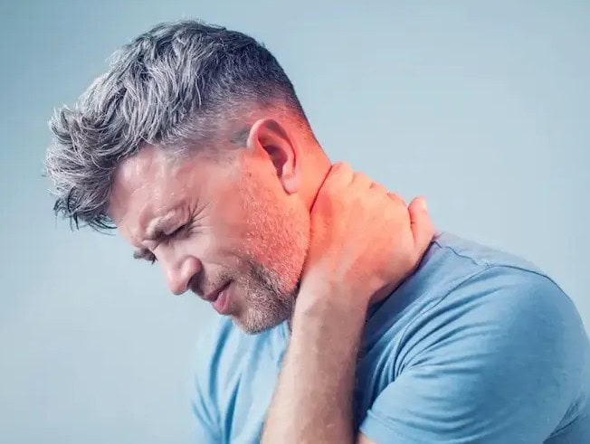 neck pain chiropractor in Tulsa man holding painful neck and shoulder area